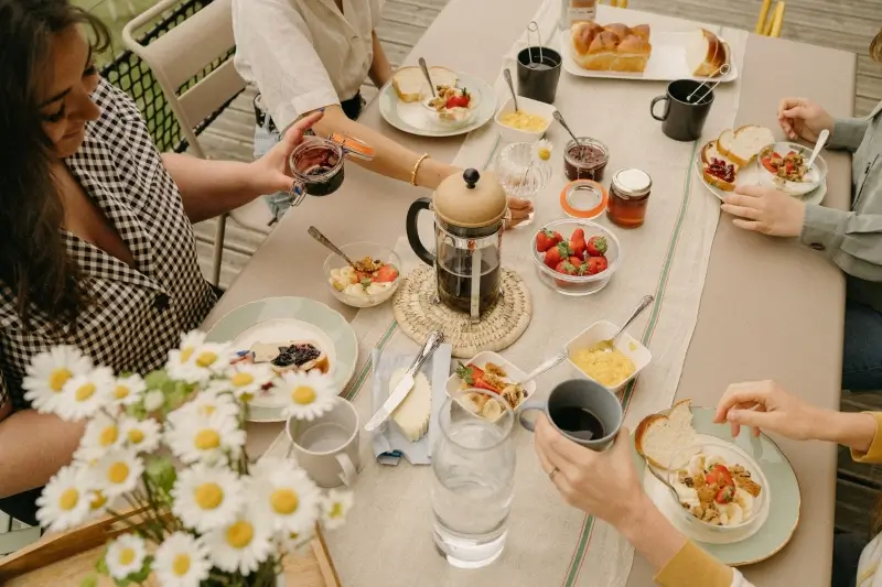 Des vacanciers prenant le petit-déjeuner sur la terrasse du gite montcuquois Le Perchoir du Quercy.