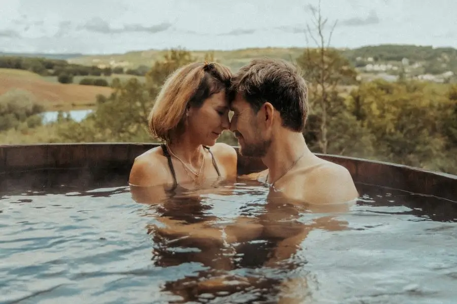 Un couple profitant d'un moment en amoureux dans le bain nordique à l'extérieur du gite.