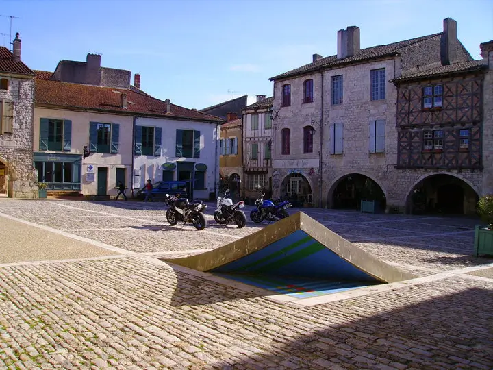 L'un des coins de la place des Cornières à Lauzerte se soulève : c'est l'œuvre surprenante d'Axel Buchholtz; situé dans cette bastide médiévale du Quercy Blanc.