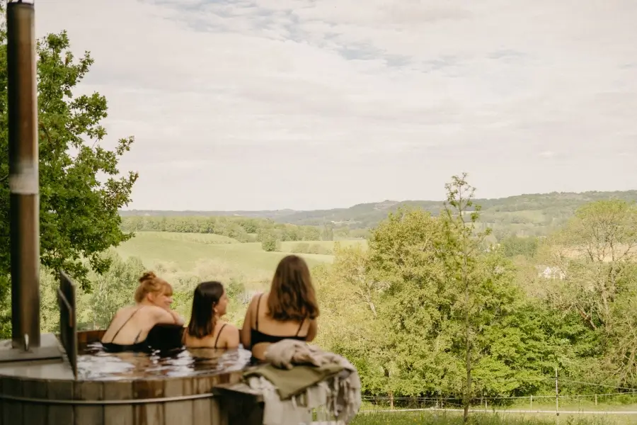 Holidaymakers enjoying the Nordic bath with a view from Le Perchoir du Quercy holiday cottage, located in Quercy Blanc, Montcuq, southern France.
